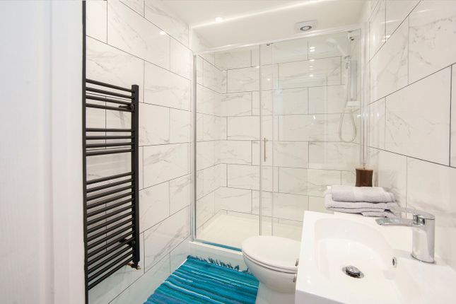 A Modern And Clean Bathroom With A Shower, Featuri...