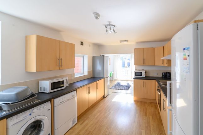 Bright, Modern Galley Kitchen With Light Wood Cabi...