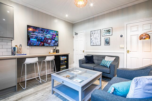 A Modern, Well-Lit Living Room Featuring A Large F...