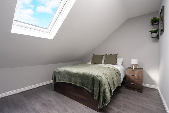 This Charming Double Bedroom Features A Cozy Ambia...