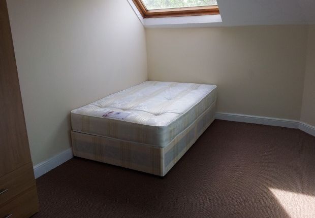 A Bright Single Bedroom Featuring A Comfortable Be...