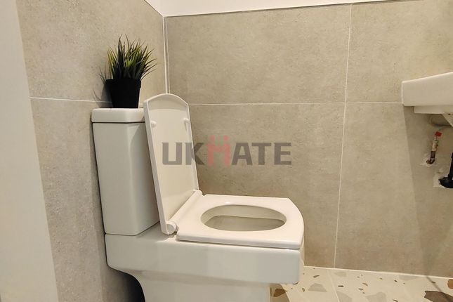 A Clean And Modern Bathroom Featuring A Toilet And...