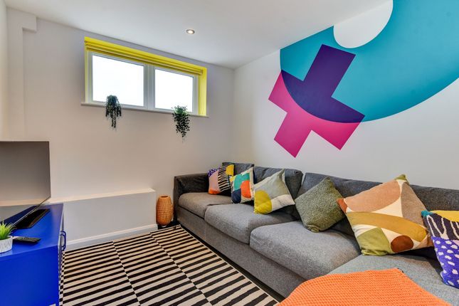 A Vibrant Living Room Featuring A Cozy Gray Sofa A...