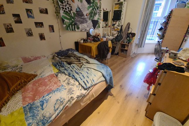 A Cozy Single Bedroom Featuring A Bright Wooden Fl...