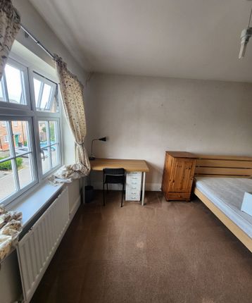 A Cozy Single Bedroom Featuring A Large Window Wit...