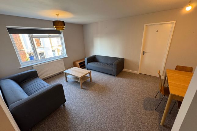 A Bright, Spacious Living Room Featuring Two Comfo...