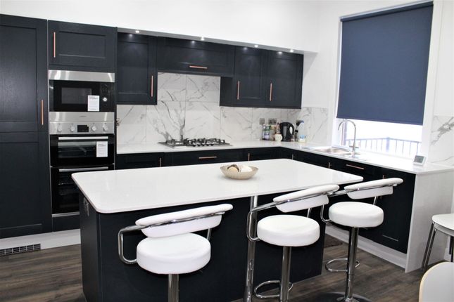 Modern Kitchen Featuring Sleek Dark Cabinetry With...