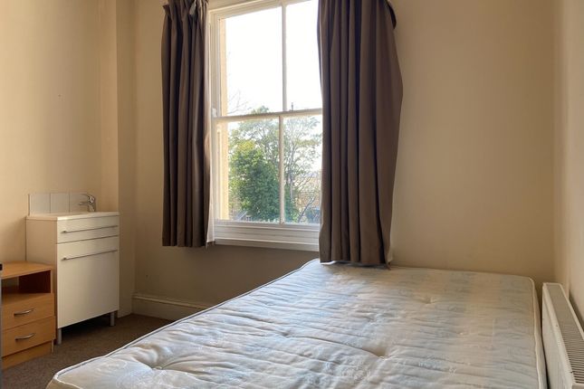 A Bright And Tidy Bedroom With A Large Window Allo...