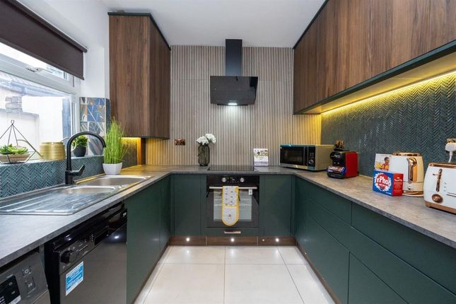 A Modern Kitchen Featuring Sleek Dark Green Lower ...