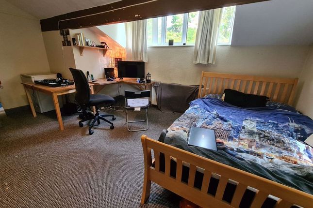 A Cozy Double Bedroom Featuring A Wooden Bed With ...