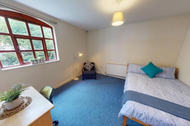 A Cozy Single Bedroom Featuring A Comfortable Sing...