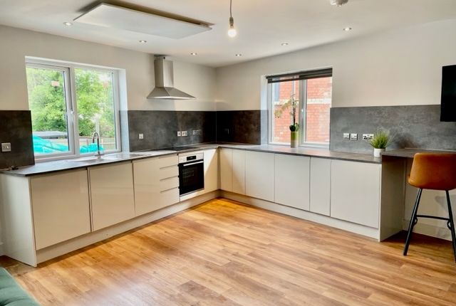 Bright Modern Kitchen With L-Shaped White Cabinetr...