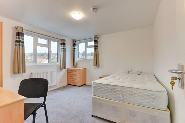 A Neat And Well-Lit Bedroom Featuring A Single Bed...