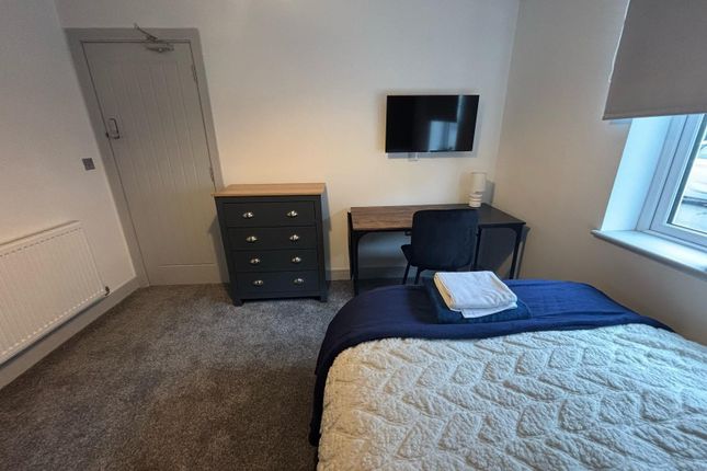 A Cozy Double Bedroom Featuring A Comfortable Bed,...
