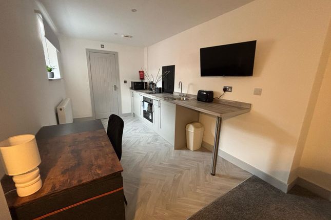 Modern Kitchenette Featuring Sleek Countertops, A ...