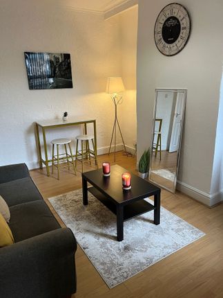 A Bright And Cozy Living Room Featuring A Comforta...