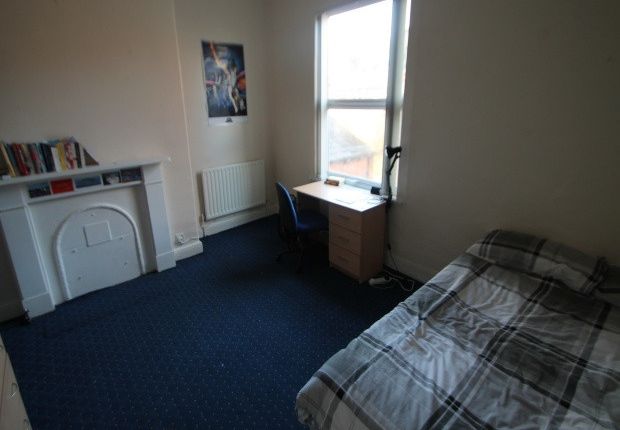 A Cozy Student Bedroom Featuring A Bed Near The Wa...
