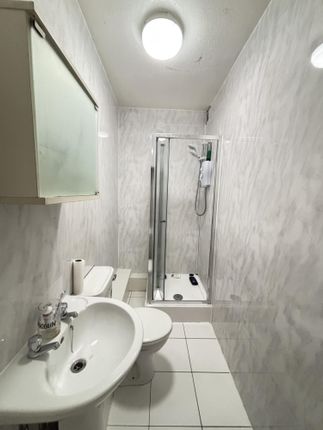 A Clean And Bright Bathroom Featuring A White Sink...