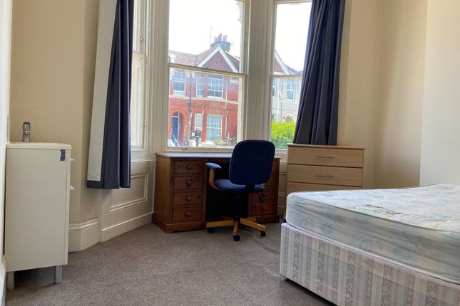 A Bright And Tidy Bedroom Featuring A Large Window...