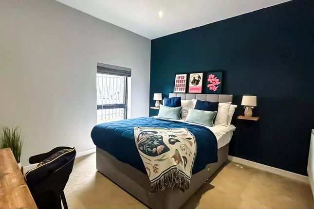 A Stylish Master Bedroom Featuring A Comfortable d...