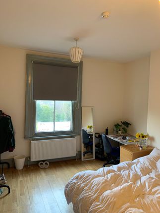 A Cozy Double Bedroom Featuring Light Wooden Floor...