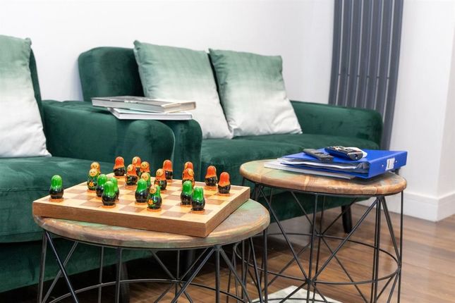 A Stylish Living Area Featuring A Dark Green Sofa ...