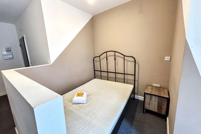 A Cozy Single Bedroom With A Metal Bed Frame And A...