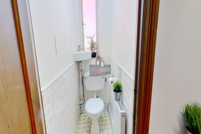 A Neat And Bright Single Toilet With A Small Sink,...