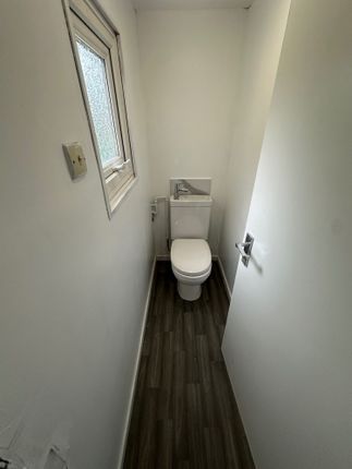 A Narrow And Clean Single Toilet With White Walls ...