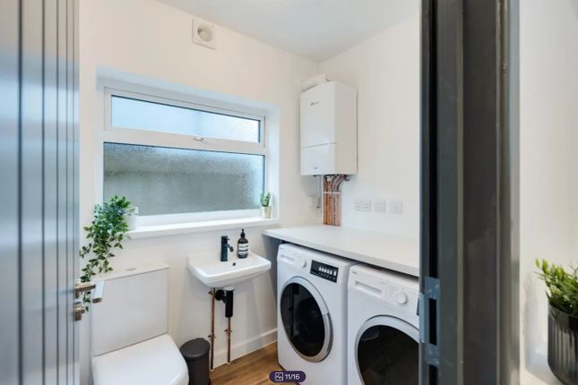 A Bright And Modern Bathroom Featuring A Washing m...