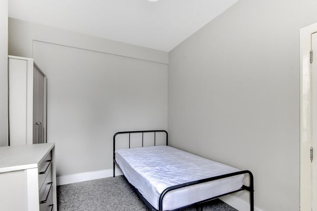 A Clean, Well-Lit Single Bedroom Featuring A Minim...