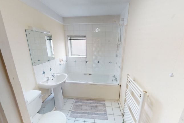 A Bright And Clean Bathroom Featuring A White Bath...