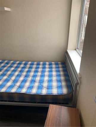 A Modest Student Bedroom Featuring A Single Bed Wi...