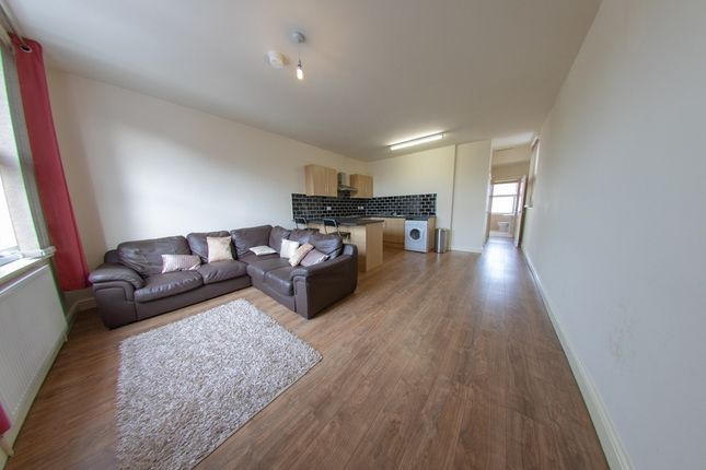 A Spacious And Well-Lit Living Room Featuring A Co...