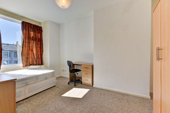 A Cozy Single Bedroom Featuring A Simple Bed, A Wo...