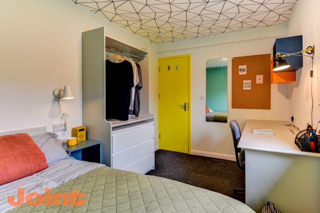 A Cozy Bedroom Featuring A Bed With A Beige Quilt ...