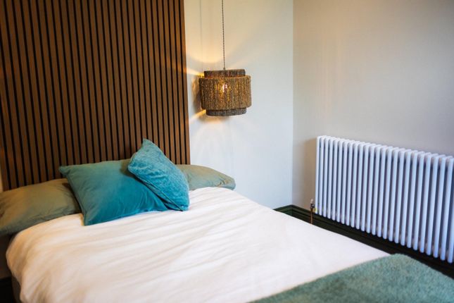 A Cozy Double Bedroom Featuring A Stylish Wooden S...