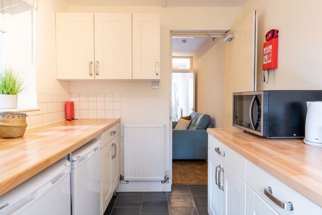 Bright Galley Kitchen With Warm Wooden Worktops, W...