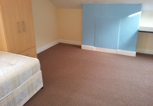 A Neat And Simple Bedroom Featuring A Single Bed A...