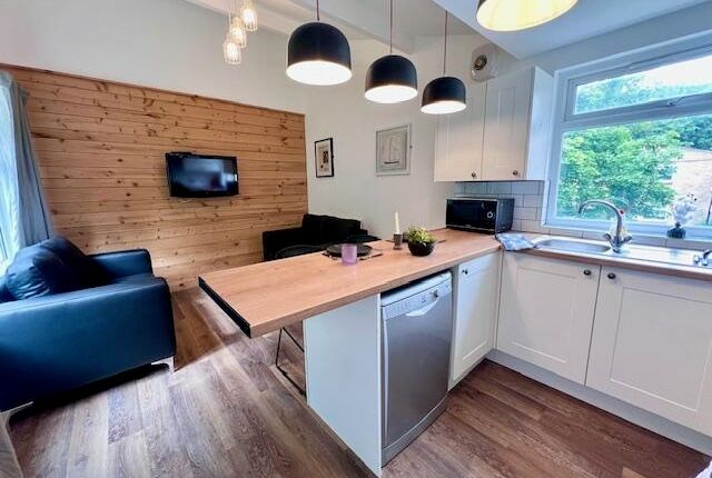 A Modern Kitchen With White Cabinetry And A Wood-F...