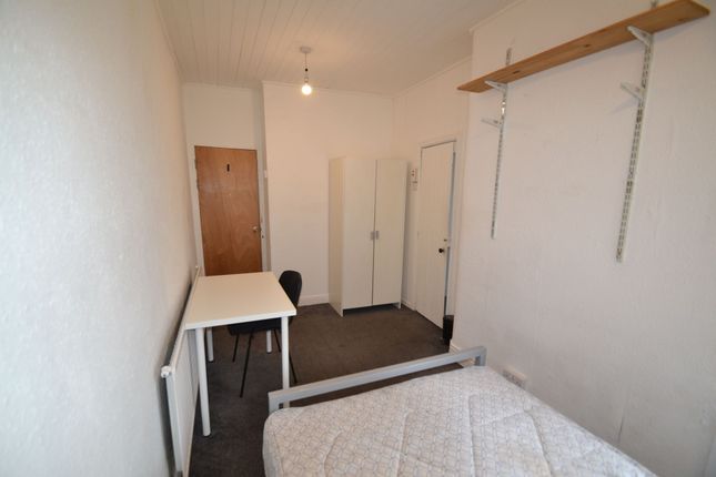 A Compact Single Bedroom Featuring A Simple Desk A...