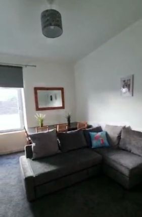 Bright Living Room Featuring A Comfortable Grey L-...
