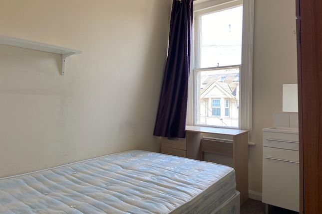 A Well-Maintained Bedroom With A Large Window Allo...