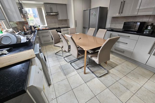 A Clean And Well-Lit Modern Kitchen With White Cab...