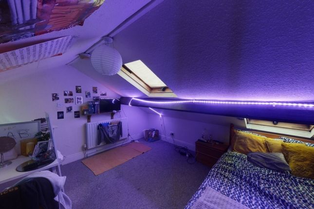 A Cozy And Stylish Attic Bedroom Featuring A Comfo...
