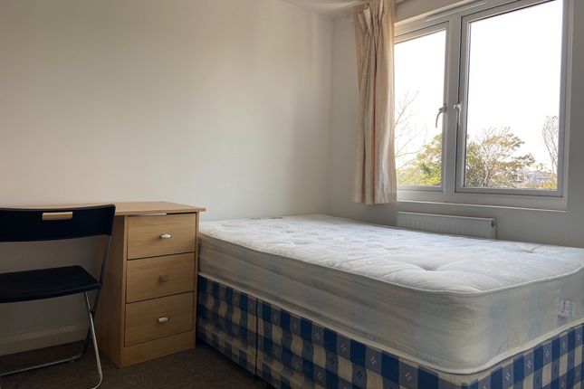 A Tidy And Well-Lit Bedroom With A Comfortable Dou...