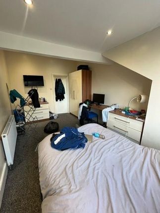 A Cozy Bedroom With A Neatly Made Bed, Featuring A...