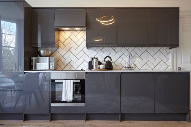 A Modern And Clean Kitchen Featuring Sleek Grey Ca...