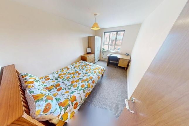 A Cozy Single Bedroom Featuring A Bed With A Color...