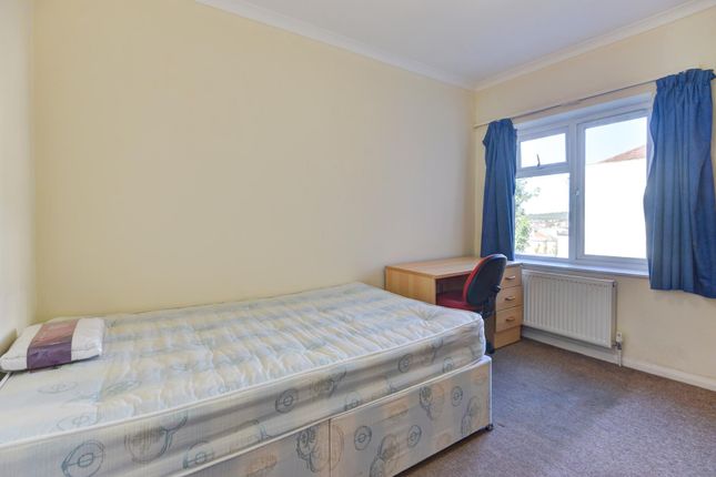 A Tidy Bedroom With A Single Bed Placed Against Th...